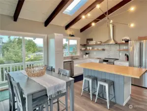 The upper level living space is wide open.... great for entertaining.  Gorgeous butcher block island and custom floating shelves add a designer touch to the aesthetic.  Access to upper, wrap around deck is right through that slider.