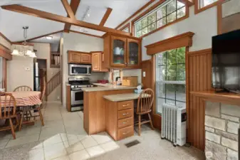 Tall ceilings with extra windows for lots of light and views of nature. Built in desk and extra kitchen cabinet space. Kitchen also has a pantry area near the fridge.