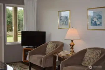 Cozy living room has slider to grassy area and beach beyond.