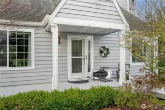 Covered porch entry with an ornate front door.