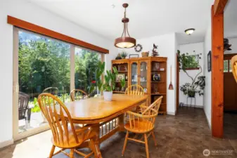 The dining room looks onto the patio and garden areas with the spacious and level lawn beyond. The very large sliding glass door makes the patio additional living space in the nice weather.