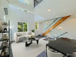 Elegant living area with a sleek glass wall showcasing a staircase leading to the upper levels.