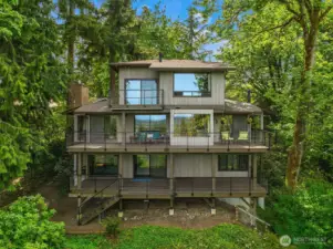 A view of the back of the home offering three decks and windows showcasing incredible views from all three levels.