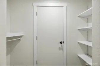 This walk-in closet offers practical built-in shelving and hanging space, making organization simple and satisfying.