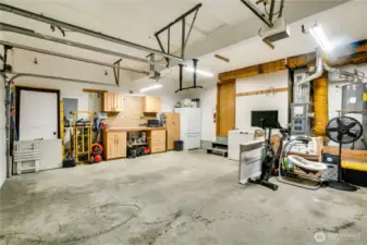 Along with parking spaces, the attached, 2-car garage offers built-in shelving, cabinets, a workbench, and pegboard. You'll also find a chest freezer and additional freezer-fridge, and the water heater, furnace, and electrical panel in here for easy access.