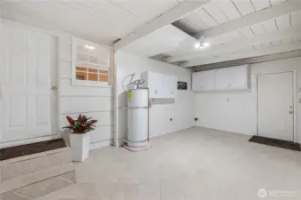Large, nicely tiled area w/ laundry hook ups, cabinets, storage area, and ceremaic heater.  (Top door comes from Kitchen; Door on right leads out to side of home)