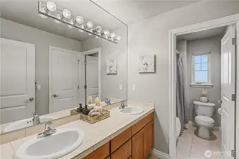 2nd floor hall bath with double vanity and private shower/toilet area