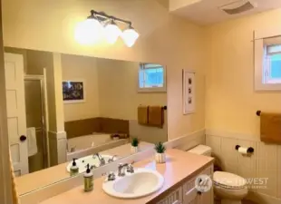 Hall bath offers wide vanity cabinet, soaking tub & separate shower.
