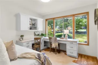 Third bedroom with custom built-ins and beautiful framed windows highlighting the front yard.