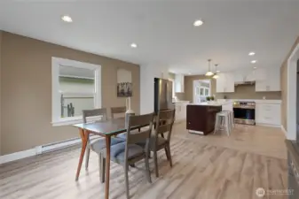 View of the dining area and open kitchen from the front window.