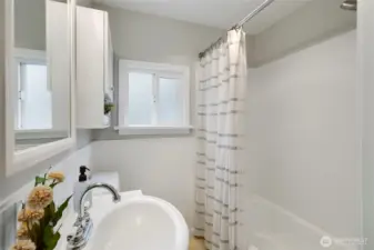 Bathroom features ample natural light and a neutral color palette.