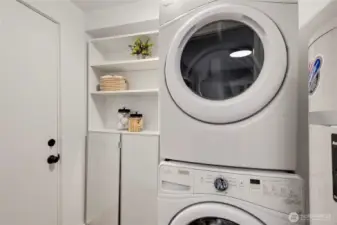 laundry area with stackable appliances and ample storage space for a streamlined and efficient layout