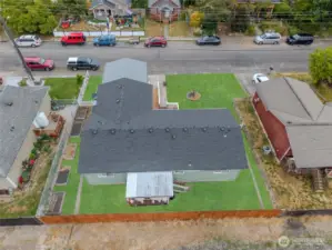 Newly installed drainage system at the rear of the home visible on each side of the home. Raised garden beds get full sun. Grass has been photo edited.