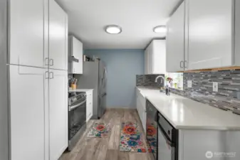 This charming kitchen features new light fixtures, laminate flooring, SS appliances including a trash compactor and a built-in pantry.