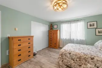 A different angle of the primary bedroom shows the closet. The same laminate flooring runs throughout the home.