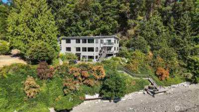 Back and side of the home. Easy access to your own 150 feet of waterfront with tideland rights, your own mooring buoy and where beachcombing and endless memories are made.