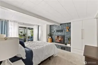 Main level bedroom has three closets, woodburning fireplace and sliders to backyard patio