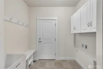 The laundry room has storage and hooks and connects to the 2 car garage.