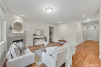 A view of the living area with front door and primary bedroom entrance.