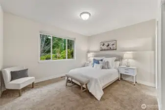 The primary bedroom is spacious and looks out over the private and peaceful backyard.