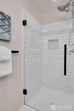 Hall bath features a beautiful glass shower door.