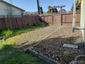 The right side of the house has a drive-through gate, with RV parking in the back yard.