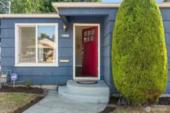 The warm exterior color palette and large picture window hint at the bright, inviting interiors within.