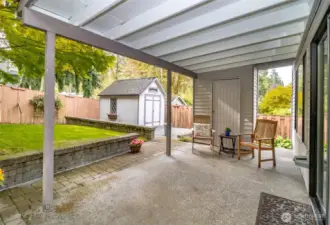 Covered patio off family room with small shed