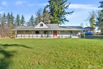 Welcoming country home with covered front porch and gated entry.