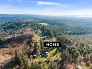 Peaceful country surroundings with open land and treed backdrop for privacy.