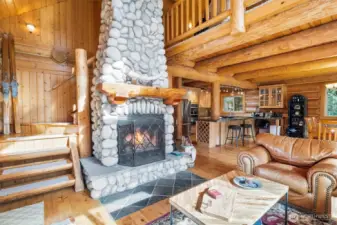 Custom stone, wood-burning fireplace adjacent to stairwell.