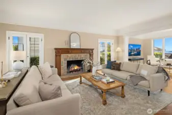 Grand living room with a wood burning Batchelder tile fireplace and original newly refinished hardwood floors.