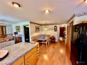 In this photo you see the front entry, breakfast nook with built in corner bench,  dining room with ceiling fan and the access to the living room.