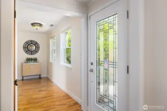 Well lit entry off of a covered porch with a coat closet and foyer space.
