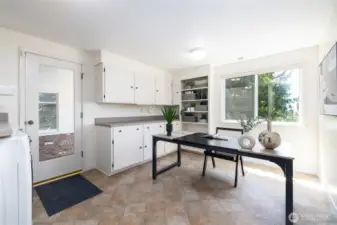 Large utility room has been used by residents as an office. Plenty of counter space and storage here as well for hobbies, pantry, or as we see here, an office.