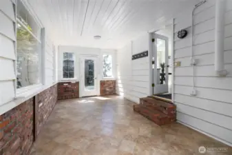 Sunroom off of the garage shows the back door to the house and the door out to the deck.