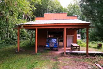 Terrific shop with an area to work on cars under cover.