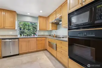 Well laid out kitchen has tons of cabinets, plant window to grow your own herbs, cooktop and warming drawer, built in oven and microwave.