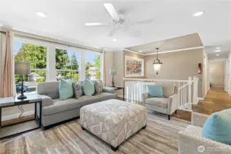Large living room with ceiling fan and beautiful slate flooring. Open view to entry and hallway adds welcoming flow.