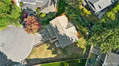 Aerial view shows this home’s large lot with spacious front and side yards plus a long driveway offering plenty of parking.