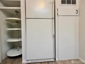 Kitchen pantry with lazy Susan shelving, and refrigerator.