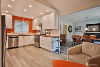 Another view of the kitchen and your first glimpse of the dining room. A better shot of the extended counter and counter stool. Note the door (to the left of the round mirror) in the dining room goes to the garage.