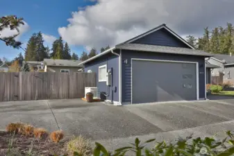 Expansive aggregate driveway is low maintenance and provides plenty of space for guests or your recreational vehicles. Notice the Generac whole house automatic generator to the left of the two car garage.