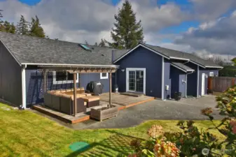 Let's go back inside, down the hallway, and check out the Primary suite & other two bedrooms. The window behind the outdoor sofa belongs to the Primary bedroom. There is a door from the garage to the yard-see right edge of this photo.