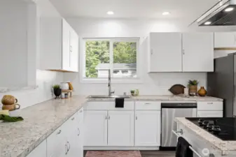The kitchen is spacious and has stainless appliances and white shaker-style cabinets.