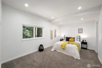 The primary suite is very spacious and looks out toward the evergreens.