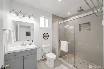The primary bath has an oversized tiled shower with a sliding glass door. This has all been updated.