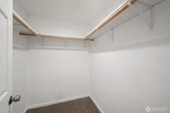 The walk-in closet in the primary bedroom is spacious and there is a lot of hanging space.