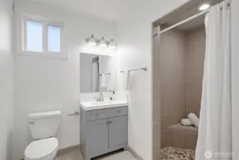The guest bath that is open from the hallway or the 2nd bedroom has a lovely tiled shower with a bench.