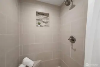 The tiled shower is beautiful and has an accent niche  for shampoos and conditioners.